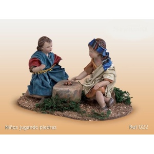 Niños jugando a piedras barro lienzado