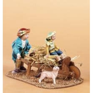 Niños con carretilla en barro y tela