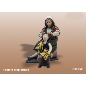 Pastora despiojando a niño en barro lienzado