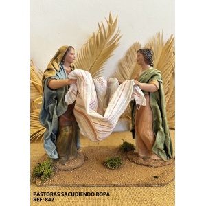 Pastoras sacudiendo ropa en barro lienzado