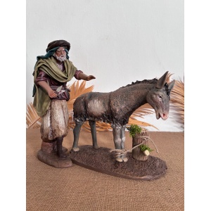 Pastor esquilando burro en barro lienzado